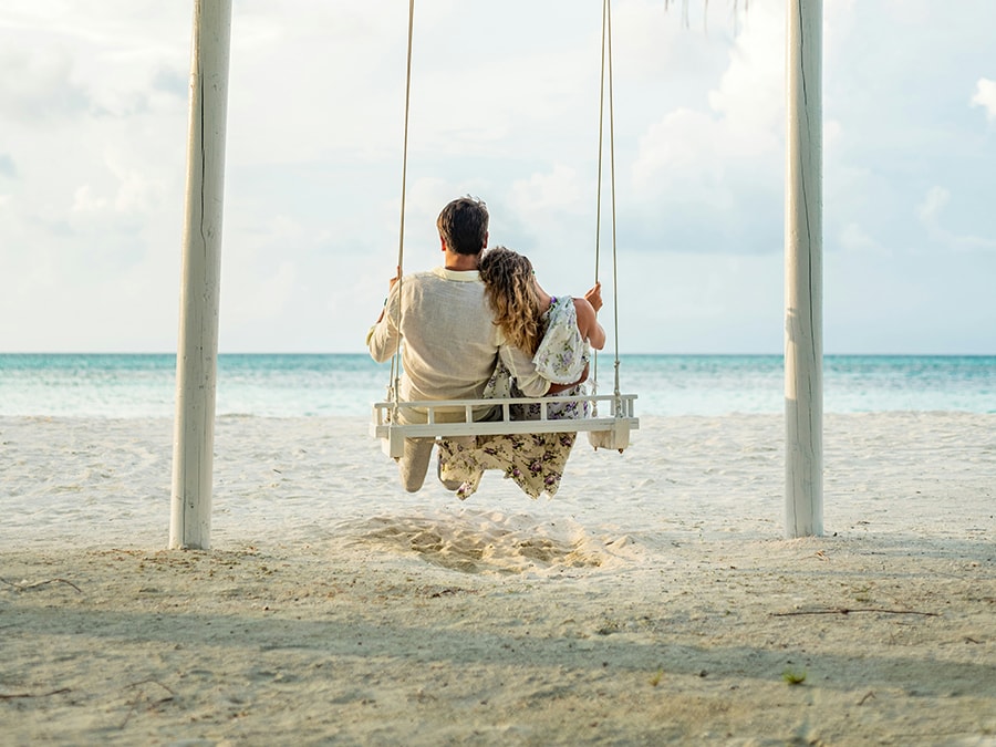 A couple on a swing at the beach